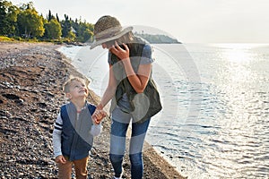 Are you having fun yet. a young woman and her son enjoying a walk by the water.