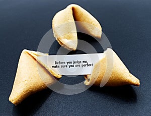 Before you judge me, make sure you are perfect. Cracked chinese fortune cookie with motivational message