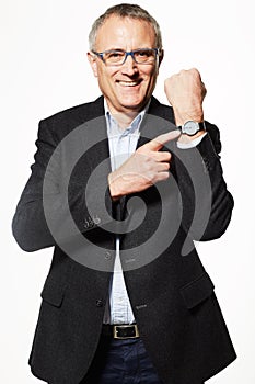 You just made it. Studio portrait of a mature businessman pointing to his watch.