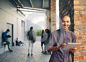 You learn something new everday. Portrait of a young man using a digital tablet outdoors on campus.