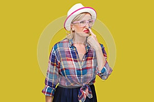 You are liar. Portrait of angry modern stylish mature woman in casual style with hat, eyeglasses standing looking and touching