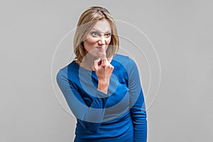 You lie! Portrait of angry young woman pointing at her nose. indoor studio shot isolated on gray background