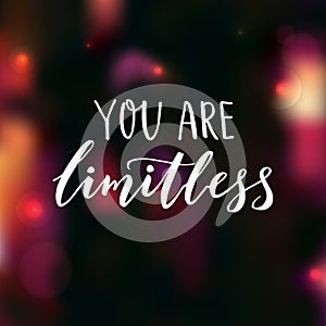 You are limitless. Encouraging quote. Motivational saying, brush lettering on dark background with pink bokeh.