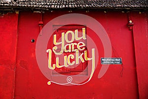 `You are lucky` text on red wall in Kochi, India