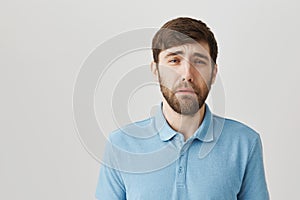 You made mature guy cry. Studio shot of sad gloomy european boyfriend, whining or crying, frowning and trying to hide