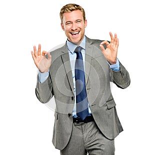 You made the perfect choice. A handsome young businessman standing alone in the studio and making an okay hand sign.
