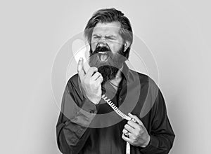 you make me feel angry. speak with friend on phone. mature male hold retro phone. guy with beard and moustache answering