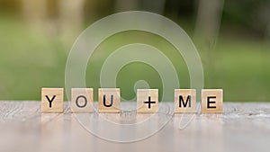 You and me word Written With wood Blocks On table nature background