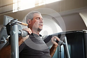 You are never too old to have fitness goals. a senior man working out at the gym.