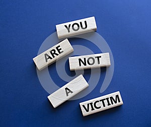 You are not your a victim. Wooden blocks with words You are not a victim. Beautiful deep blue background. Business and You are not