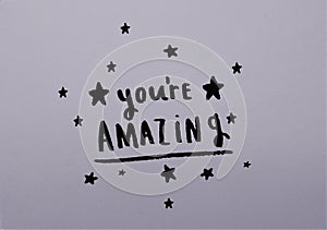 `You`re Amazing` inspirational quote on grey background
