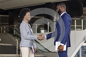 You`re hired. Business people shaking hands near office building