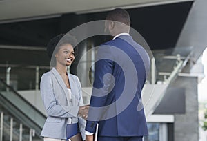 You`re hired. Business people shaking hands near office building