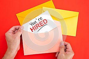 You`re Hired Concepts - Hand holding a envelope and post card