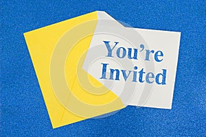 You`re Invited message on white card with a yellow envelope