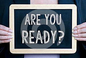 Are you ready - Businesswoman holding chalkboard with text