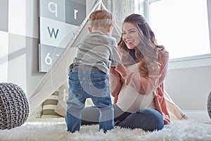 Are you ready to be a big brother. a pregnant woman bonding with her toddler son at home.