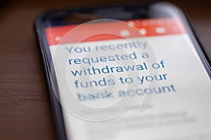You requested withdrawal of funds to bank account message on smartphone screen closeup