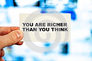 YOU ARE RICHER THAN YOU THINK motivating words man holds in his hand