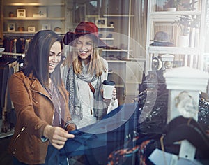 You should get it. two best friends out shopping in a clothing store.