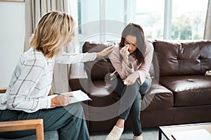 When you start talking, you start healing. Shot of a crying young woman being comforted by her psychologist during a