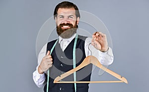 for you. tailor man use tape measure. professional male sartor with measuring tape and hanger. Handsome man in smart