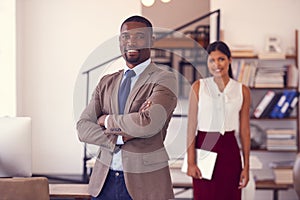 You too can work your way up to the top. Portrait of two businesspeople standing in an office.