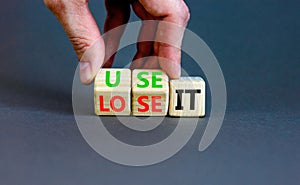 You use or lose it symbol. Concept word Use It or lose it on wooden cubes. Beautiful grey table grey background. Businessman hand