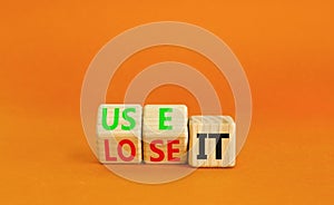 You use or lose it symbol. Concept word Use It or lose it on wooden cubes. Beautiful orange table orange background. Business and