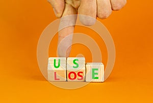 You use or lose it symbol. Concept word Use or lose on wooden cubes. Beautiful orange table orange background. Businessman hand.