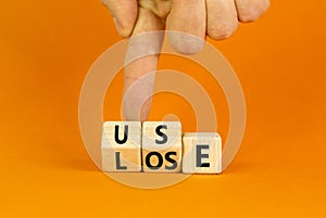 You use or lose it symbol. Concept word Use or lose on wooden cubes. Beautiful orange table orange background. Businessman hand.