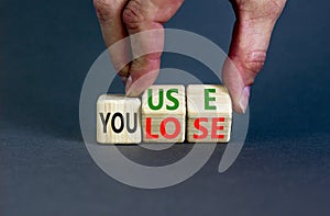 You use or lose it symbol. Concept words You use and You lose on wooden cubes. Businessman hand. Beautiful grey table grey