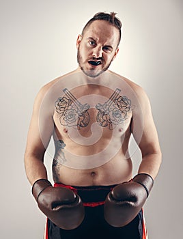 You wanna mess with me. a serious MMA fighter standing isolated on white.
