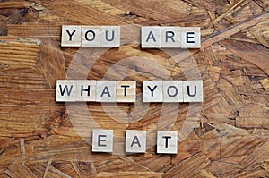 you are what you eat text on wooden square, motivation quotes.