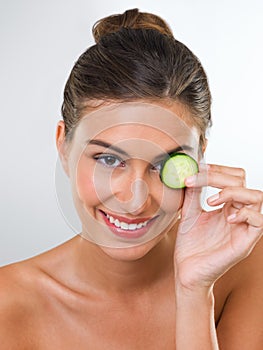 You wont catch me with bags under my eyes. Portrait of a gorgeous young woman holding a slice of cucumber over her eye.