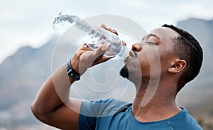 You worked hard and did well today. a sporty young man drinking water while exercising outdoors.