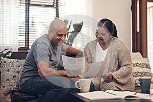 Youd be smiling too if you saved like they did. Shot of a young couple going over paperwork at home.