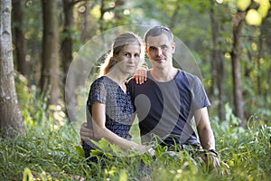 Youg couple, man and a woman sitting together outdoors enjoying nature