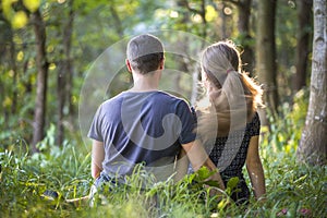 Youg couple, man and a woman sitting together outdoors enjoying nature