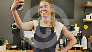 Youg female barista taking selfie at work place