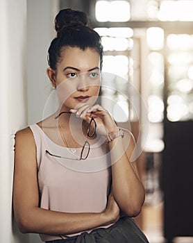 Youll find the best ideas outside the box. a young businesswoman looking thoughtful in a modern office.