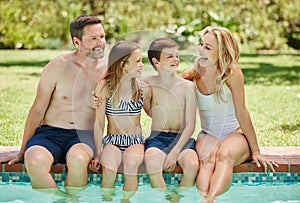 Youll always find smiling face around the pool. a couple and their two children spending time by the pool.