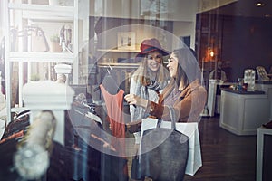 Youll look so pretty in it. two best friends out shopping in a clothing store.