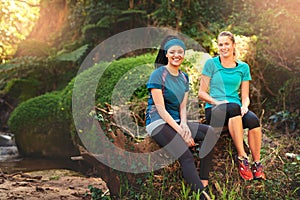 Youll never regret working out in nature. two sporty young women taking a break while out exercising in nature.
