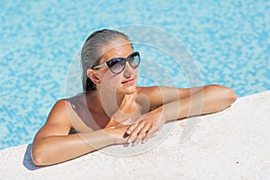 Yound beautiful woman rests at the pool