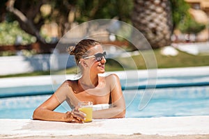 Yound beautiful woman rests at the pool