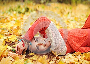 Yound cute woman have a rest lying in autumn park