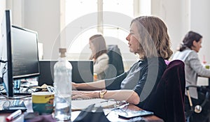 Yound devoted female software developers team working on desktop computer in IT statup company.