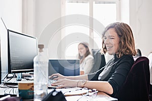 Yound devoted female software developers team working on desktop computer in IT statup company.