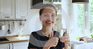 Young 20s energetic girl drinking glass of fresh pure water.